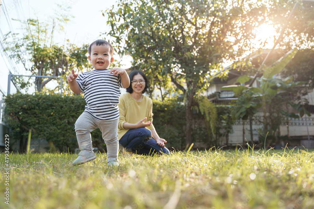 Fototapeta premium Portrait of Smiling Asian Little child son and his young mother in nature with sunlight, Happy family home.