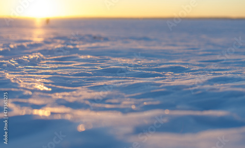 A snow crust on the frozen winter lake at sunset