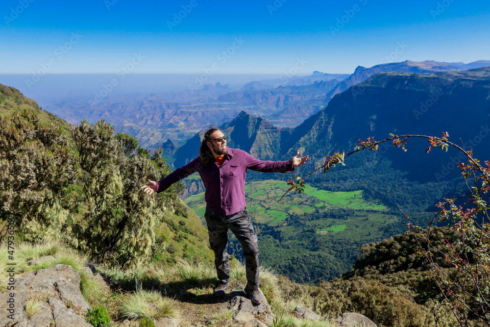 White Man Tourist posing on the Green Valley of Simien Mountains near Gondar, Northern Ethiopia