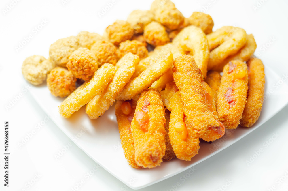 Southern fried and roast chicken bites, onion rings and mozzarella stick served on the white plate Southern fried and roast chicken bites, onion rings and mozzarella stick served on the white plate