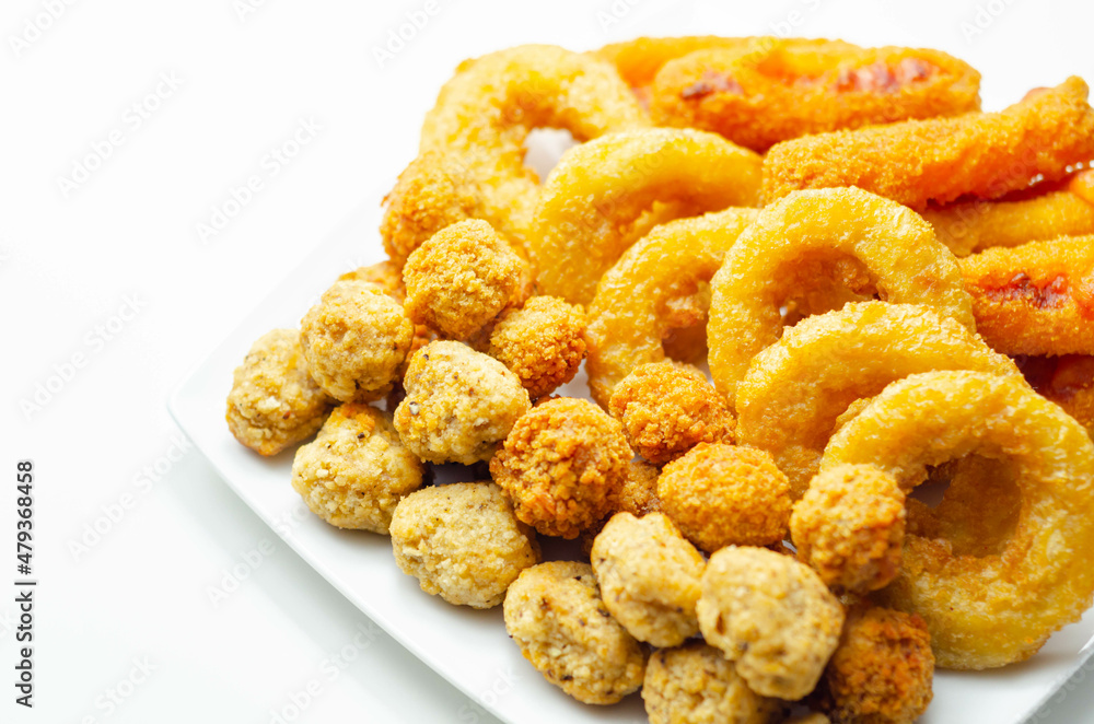 Southern fried and roast chicken bites, onion rings and mozzarella stick served on the white plate Southern fried and roast chicken bites, onion rings and mozzarella stick served on the white plate