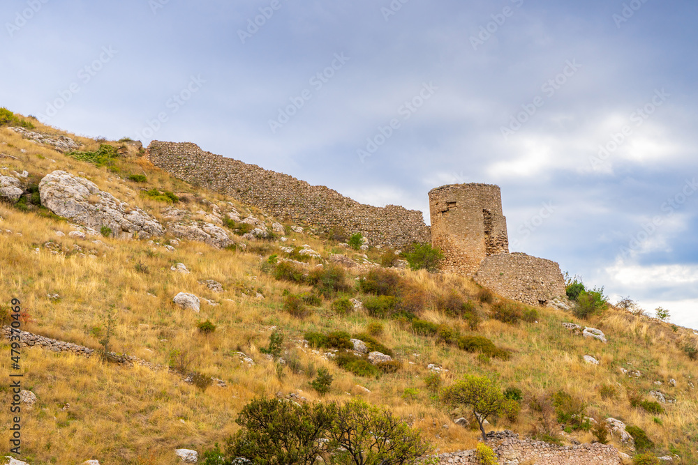 View to Barnabo Grillo tower and ruined wall of Chembalo fortress. Medieval architecture monument, landmark. Ruined stone Genoese fortress in Balaklava in Sevastopol vicinity, Crimea, Russia
