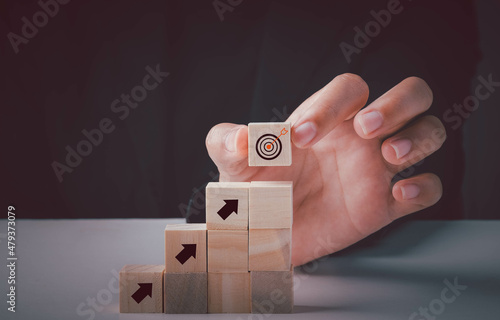 Target, Business goal, Strategy objective plan, Success and growth concept. Businessman putting target board on up arrows target icon on wooden cube block stacking.