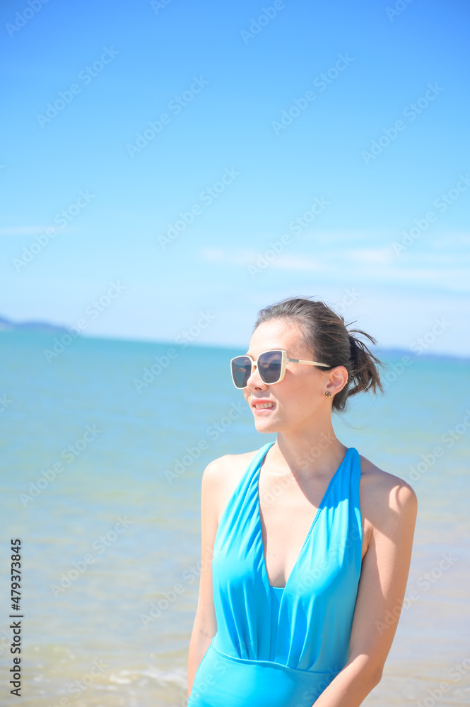 Woman enjoying beach relaxing joyful in summer by tropical blue water. model on travel wearing sun glasses. Woman enjoying beach relaxing joyful in summer by tropical blue water. model on travel wearing sun glasses.