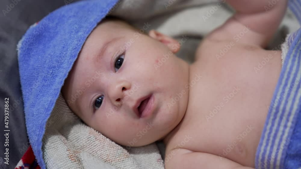 Adorable Caucasian toddler lying in towel. Nice child has been washed and resting after a bath. Portrait close up. Adorable Caucasian toddler lying in towel. Nice child has been washed and resting after a bath. Portrait close up.