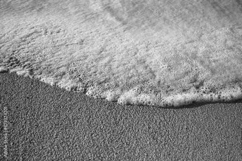 Fotografie, Obraz Texture of the beach sand with the foam. Black and white photo.