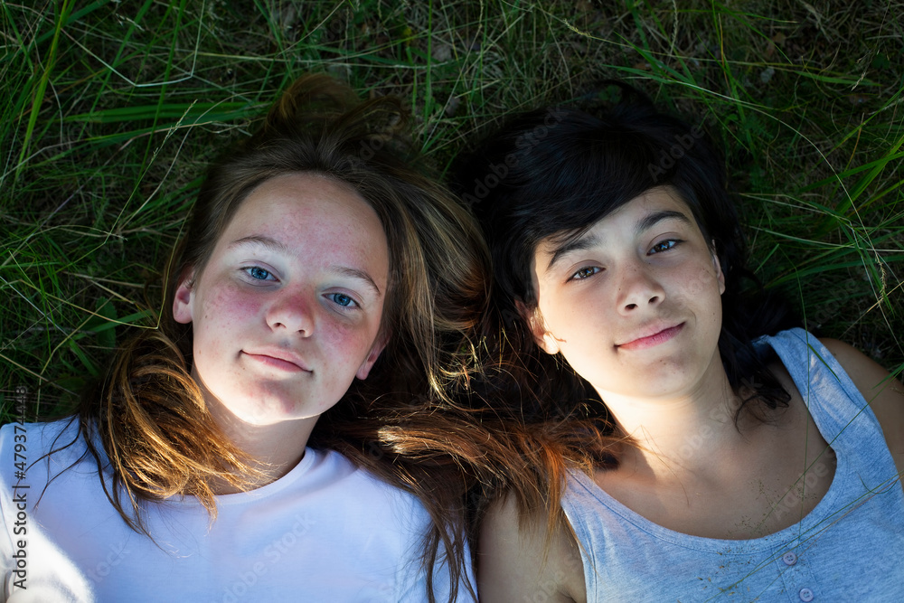 Portraite of two teenage girl lying on grass and having good time. Portraite of two teenage girl lying on grass and having good time.