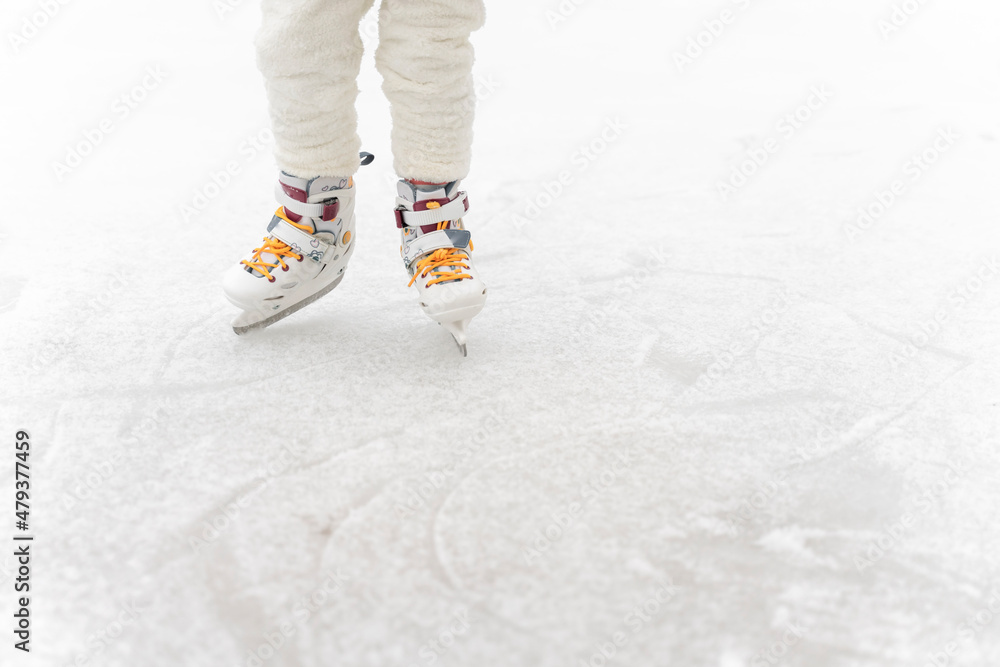 child skating on a rink, legs close-up and copy space child skating on a rink, legs close-up and copy space