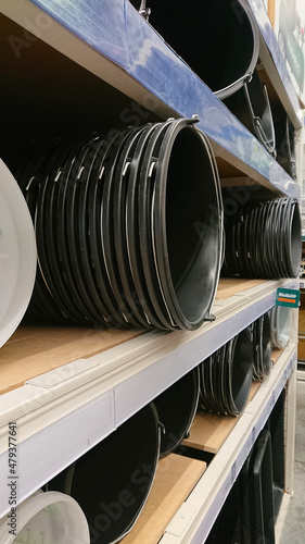 Plastic buckets are on the shelves in a building materials store.