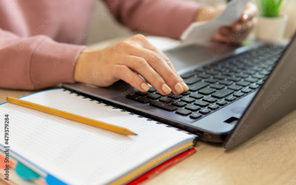 Woman paying her bills online using a laptop. close-up Woman paying her bills online using a laptop. close-up
