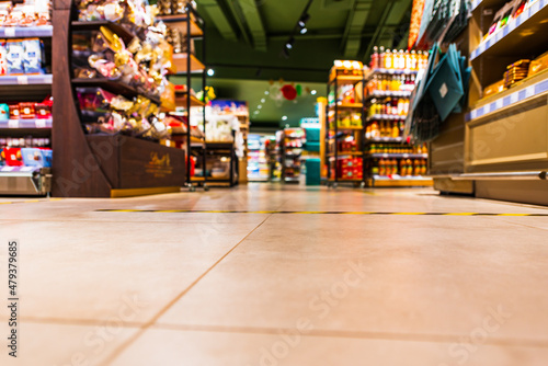 Grocery store. In the mall. Go shopping. Shelves with various goods. Product selection. Daily worries. The era of consumption. Focus on the floor. Close-up view from the level of the floor tiles.
