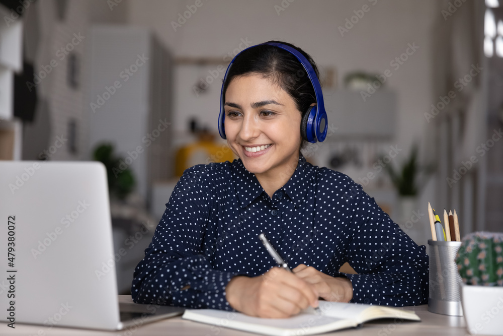 Happy ethnic Indian student girl watching learning media content ...