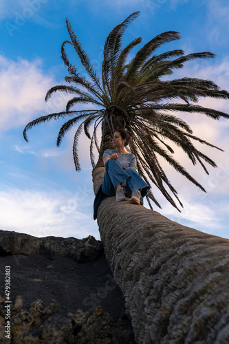 woman sitting on a palm tree in Lanzarote