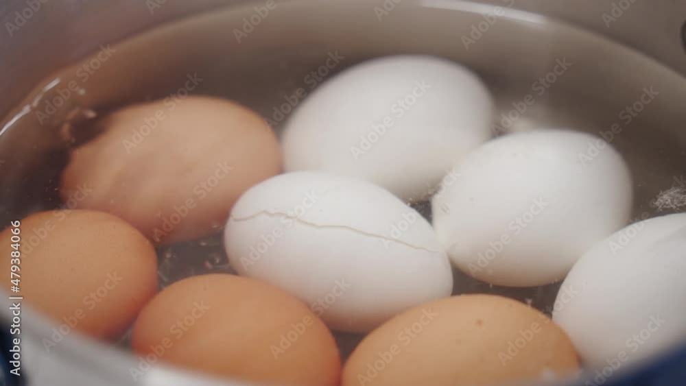 Pot with boiling water and chicken eggs on stove top, cooking white brown eggs in saucepan. High quality 4k footage Pot with boiling water and chicken eggs on stove top, cooking white brown eggs in saucepan. High quality 4k footage
