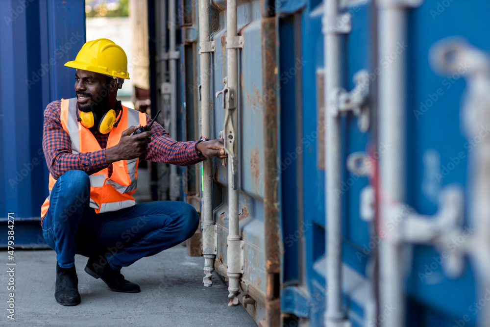 Foreman holding walkie- talkie for control working at Container cargo site. Handheld walkie talkie for outdoor Foreman holding walkie- talkie for control working at Container cargo site. Handheld walkie talkie for outdoor