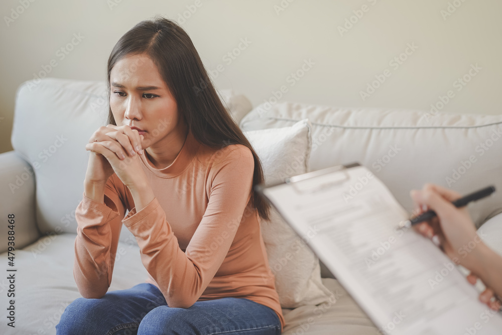 Psychology, depression. Sad, suffering asian young woman consulting with psychologist, psychiatrist while patient counseling mental with doctor woman taking notes at clinic. Encouraging, therapy. Psychology, depression. Sad, suffering asian young woman consulting with psychologist, psychiatrist while patient counseling mental with doctor woman taking notes at clinic. Encouraging, therapy.