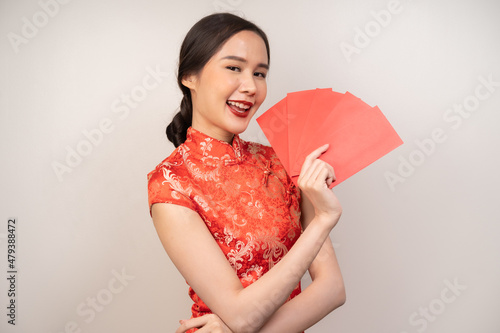 Chinese new year festival celebrate culture of china people, cheerful asian young woman, girl hand holding red envelope, ang pao ,wearing red cheongsam dress traditional. Isolated on white background. photo