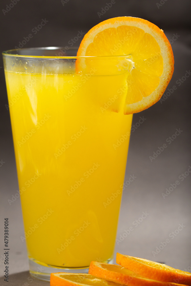 Glass of fresh orange juice with fruits cut in half and sliced isolated on gray background, clipping path Glass of fresh orange juice with fruits cut in half and sliced isolated on gray background, clipping path