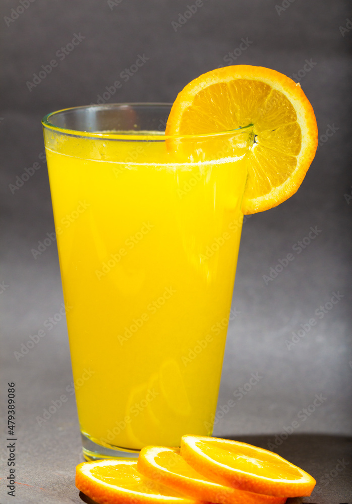 Glass of fresh orange juice with fruits cut in half and sliced isolated on gray background, clipping path Glass of fresh orange juice with fruits cut in half and sliced isolated on gray background, clipping path