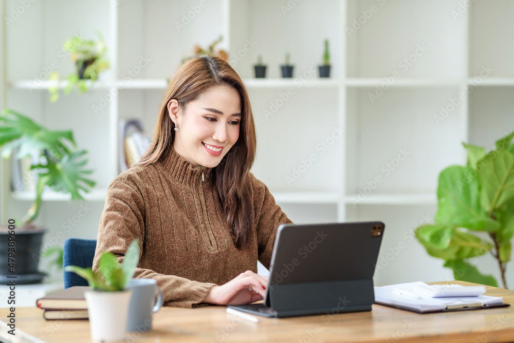 Pretty young Asian female student studying online on laptop computer. Pretty young Asian female student studying online on laptop computer.