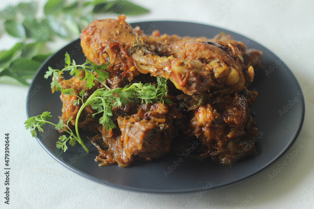 Kerala style dry chicken roast. Chicken cooked in a spicy gravy of onion tomatoes and spices served with chicken leg pieces on top