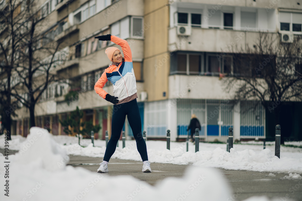 Woman does stretching before training in the snow in the winter. Woman does stretching before training in the snow in the winter.