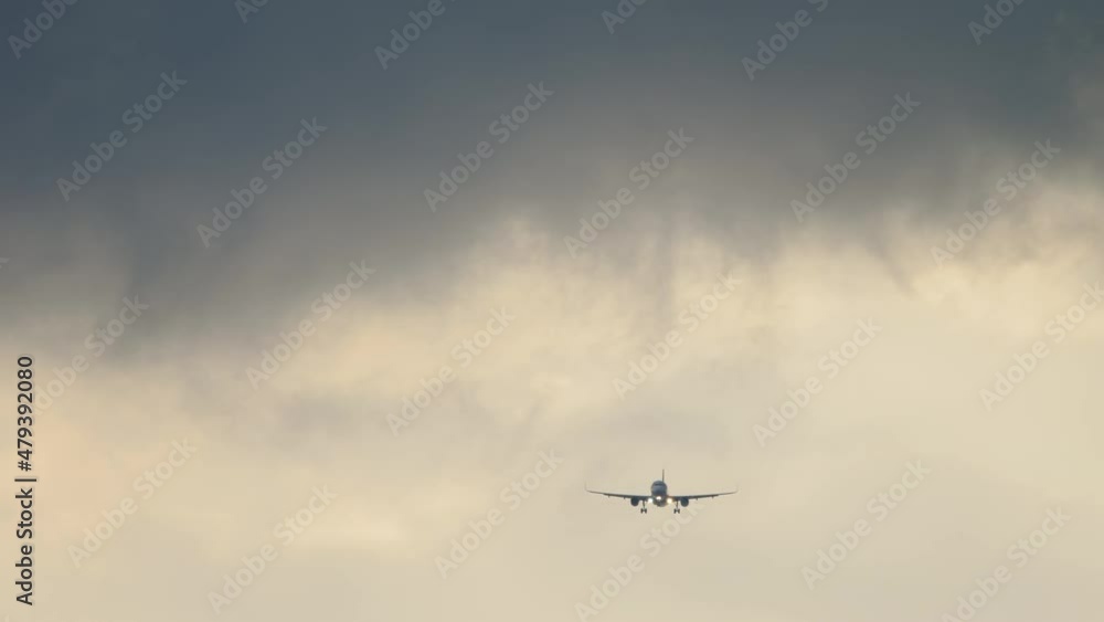 Aircraft approaching for landing against the background of dark thunderstorm clouds. Tourism and travel concept Aircraft approaching for landing against the background of dark thunderstorm clouds. Tourism and travel concept