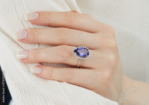 Colorful diamond ring. On the finger of a young lady.