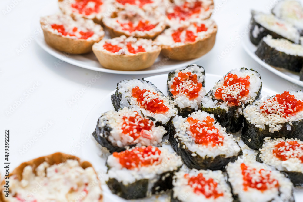 Homemade sushi covered with red caviar on a festive table, Japanese food, holidays. Homemade sushi covered with red caviar on a festive table, Japanese food, holidays.