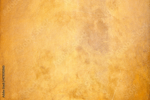 Rough orange plastered wall with tiny cracks