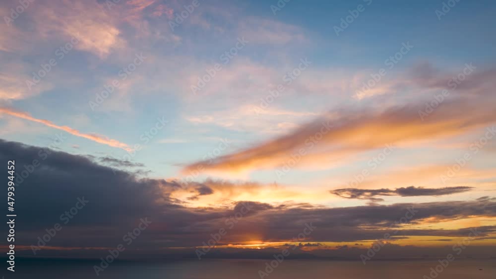 Time lapse view of a cloudy sunset over the sea with orange and blue colors Time lapse view of a cloudy sunset over the sea with orange and blue colors