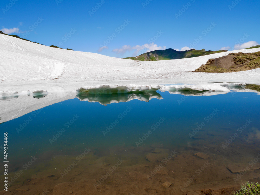 Reflection in the Blue Lake, Portlahorn, in early spring. Vorarlberg, Austria. Reflection in the Blue Lake, Portlahorn, in early spring. Vorarlberg, Austria.