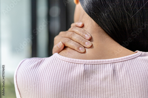 Person holding on to the nape of the neck, which comes from pain from work, pain from sitting and typing at a computer for a long time, causing pain in many areas of the body. Office Syndrome concept.