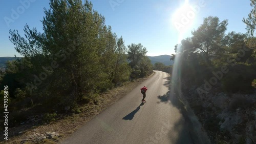 Man riding a longboard on sunset in a road. Downhill Skateboard Longboarding 4k drone. Wood rider road with longboarder. Landscape free and wild downhill.