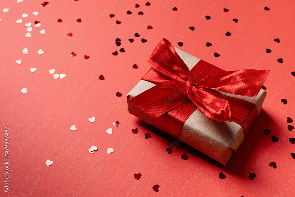 Red gift box with a ribbon for Valentines Day celebrating on red solid background with copy space Red gift box with a ribbon for Valentines Day celebrating on red solid background with copy space