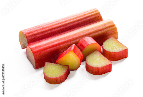 Whole sticks of rhubarb stem with few piece of cut rhubarb, isolated on a white background.