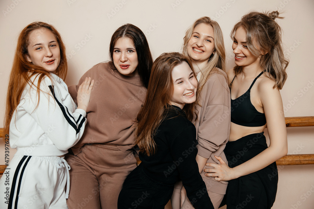 Cheerful women in sportswear, standing against the wall, ready to start fitness classes, the concept of a healthy sports lifestyle. Generation Y concept Cheerful women in sportswear, standing against the wall, ready to start fitness classes, the concept of a healthy sports lifestyle. Generation Y concept