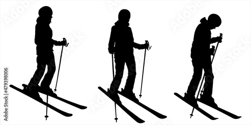 Woman skier. Girl in a ski suit with ski sticks in her hands and skis on her feet. The skier stands half sideways, bending his knee. Winter sports. Female black silhouette isolated on white background