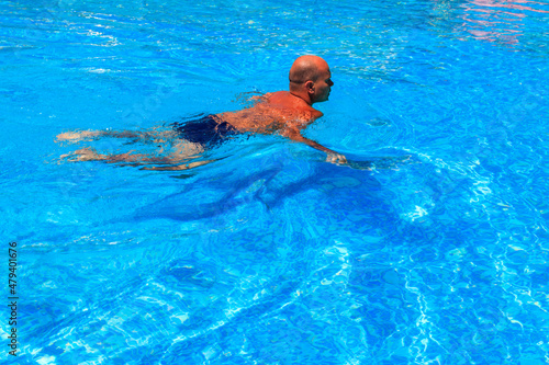 Handsome man relaxing in the swimming pool