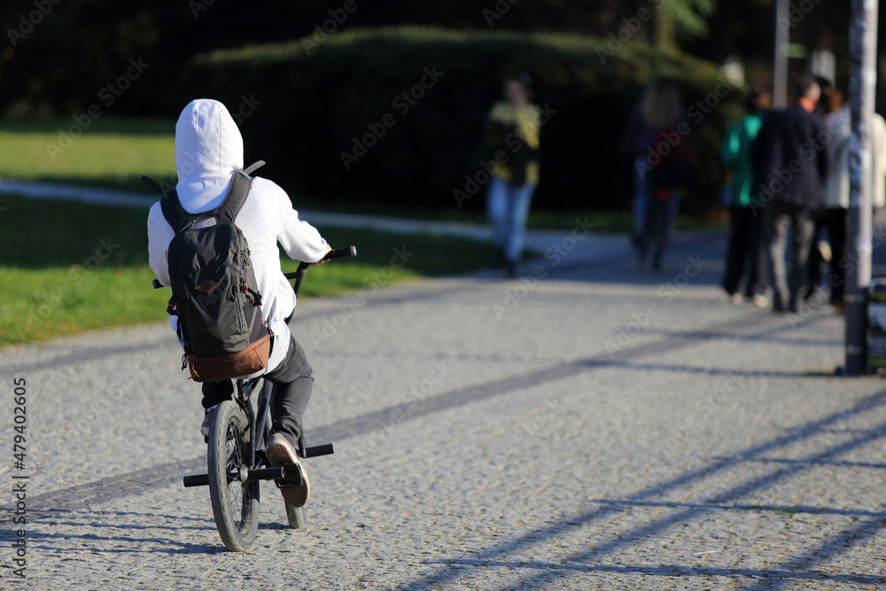 Mężczyzna na rowerze z plecakiem jedzie ścieżką rowerową w mieście, Wrocław.	