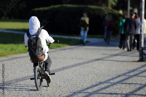 Fototapeta Naklejka Na Ścianę i Meble -  Mężczyzna na rowerze z plecakiem jedzie ścieżką rowerową w mieście, Wrocław.	