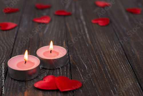 Romantic concept with candle and hearts on a wooden background. St. Valentine s Day