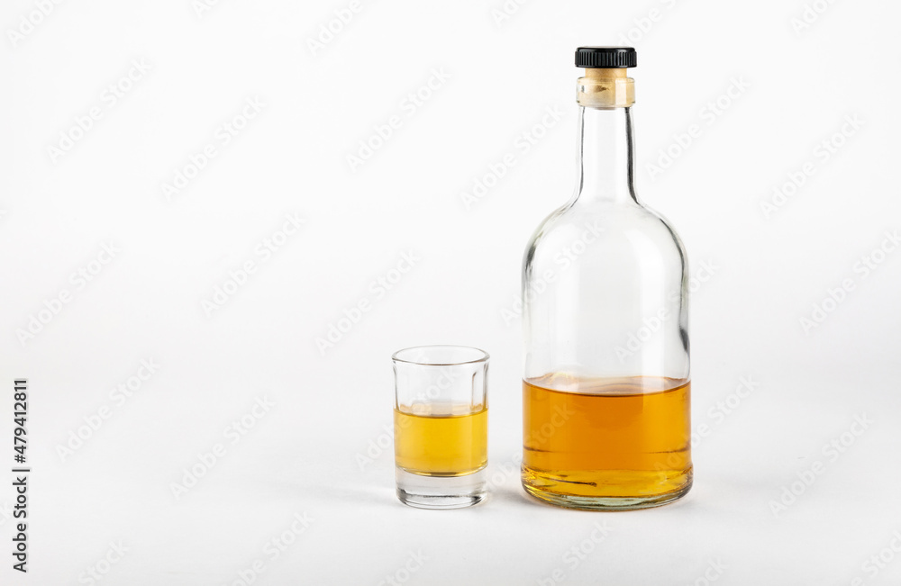 Glass and bottle of alcohol on a white background.Concept of alcoholism. Glass and bottle of alcohol on a white background.Concept of alcoholism.