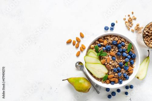 Flat lay healthy breakfast with granola, natural yoghurt, fruits and blueberry berry on white background with copy space top view