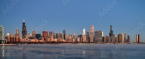 Sunrise reflections on the big city skyline along the frozen waterfront in winter