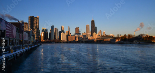 Sunrise reflections on the big city skyline along the frozen waterfront in winter