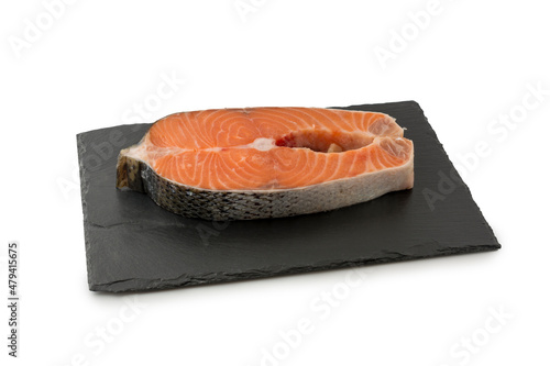 a cut piece of fresh salmon for steak on a stone board white background.