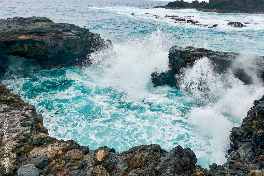 Large waves crashing against the volcanic rock. A brave fisherman casts his reel into the sea. La Palma, Canary Islands - Spain