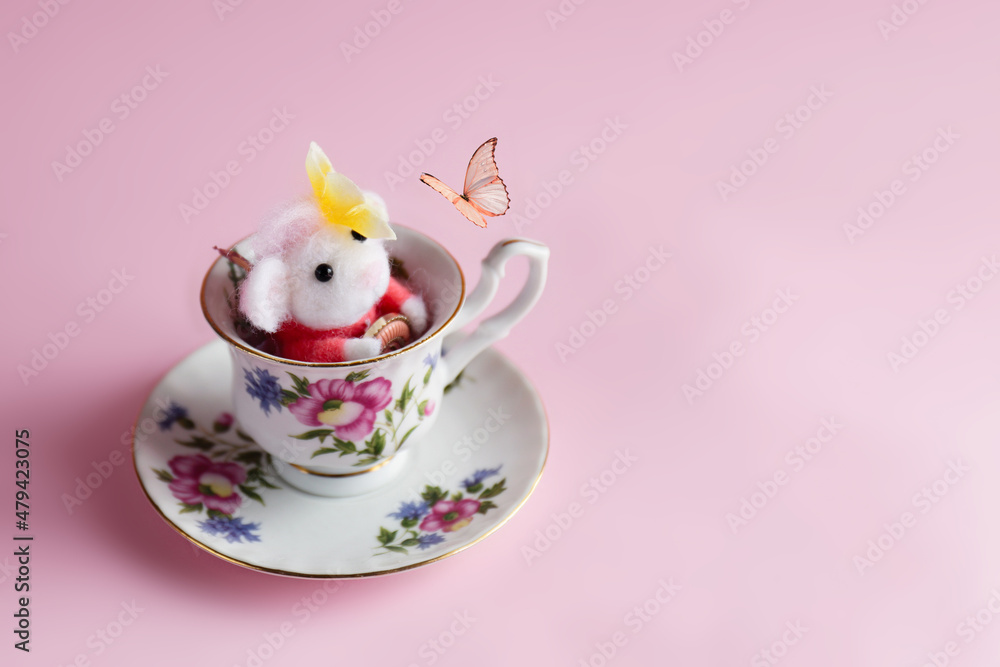 Fototapeta premium Topolino di lana nella tazza gioca con la farfalla