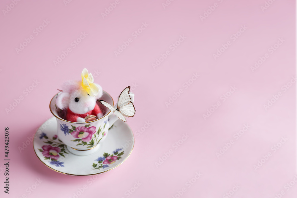 Topolino di lana nella tazza gioca con la farfalla Topolino di lana nella tazza gioca con la farfalla